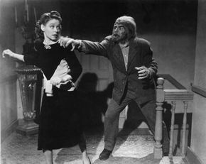 1945年左右:一个狼人追着一个女人上了楼，抓住了她的肩膀，这是一部来历不明的电影剧照。＂border=