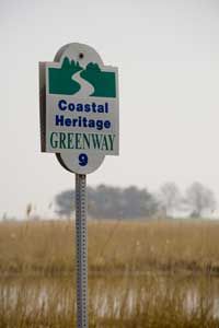 A sign identifies the wetlands route as a Coastal Heritage Greenway in Delaware.