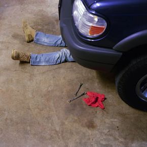 Guy Rolls Down Hill In Tire Towards Car