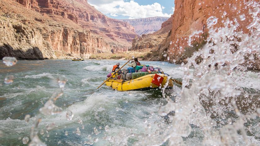 group paddling a whitewater raft through rapids on Colorado River.