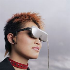 戴着虚拟现实头戴式显示器的女人”width=