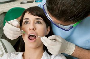 woman getting teeth cleaned at dentist office