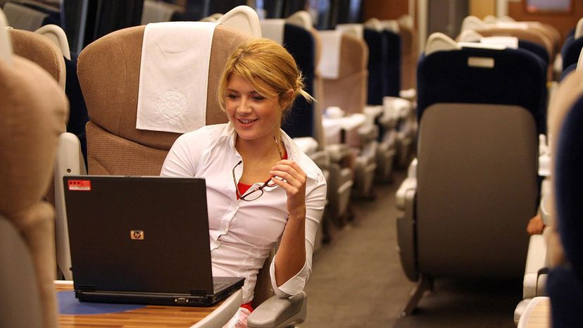 A commuter using a laptop on a bus.&nbsp;