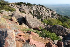 Outdoor rock object amidst scenic landscape.