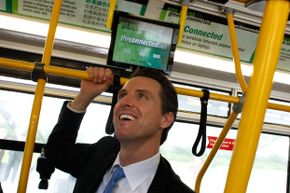 San Francisco mayor Gavin Newsom inspects the Connected Bus, which features WiFi, live route information and wait times via touchscreen monitors, and a 'Green Gauge' that gives information about the environmental impact of the bus.