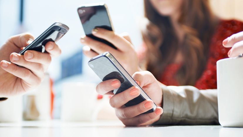 Three people holding different wifi phones.