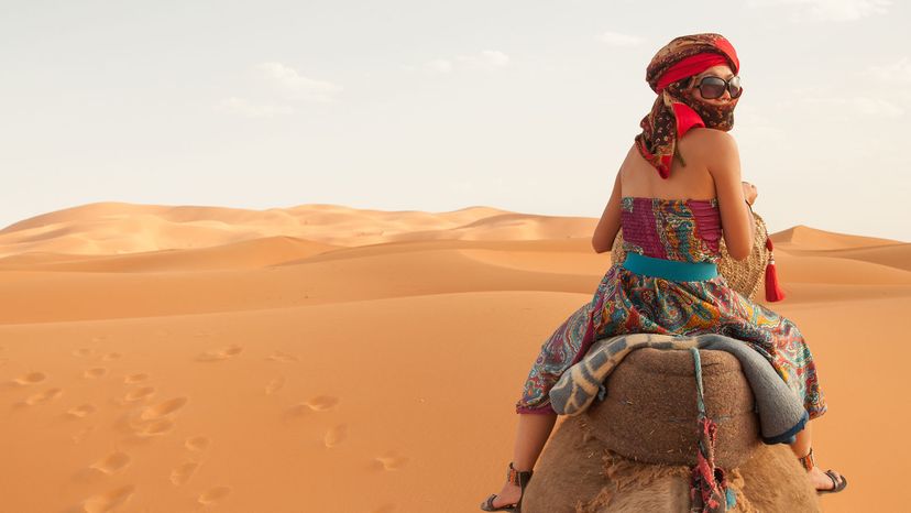 women on camel in desert