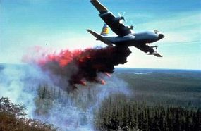 An air tanker drops water and fire retardant onto a wildfire.