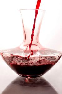 Filling glass decanter with red wine for aeration