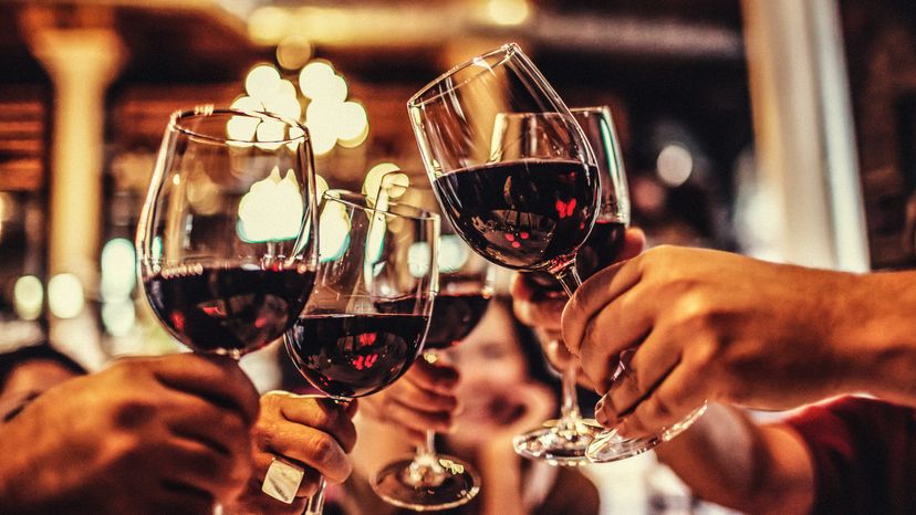 A group of five friends cheering with their wine glasses 