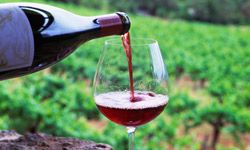 A glass of wine being boured in a vineyard