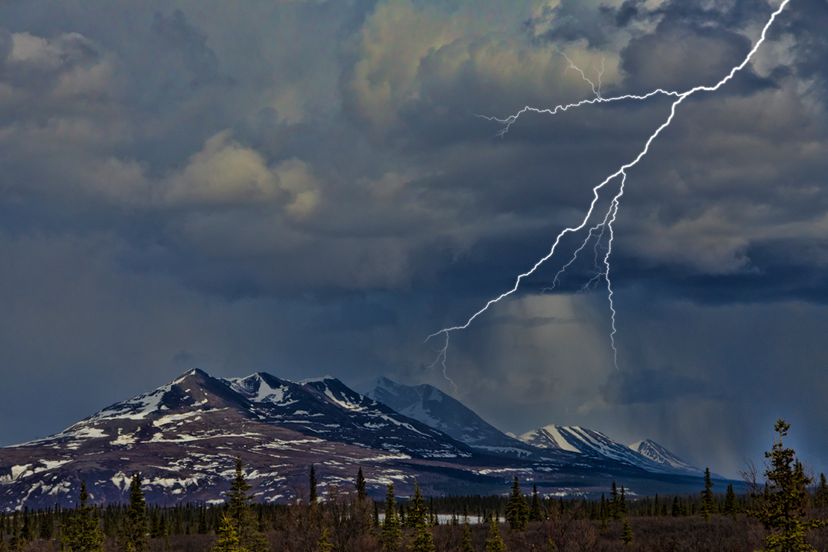 Lightning strike near snow covered mountain