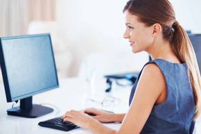 Woman working on a desktop computer.