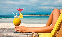 Woman sipping drink in tropical location