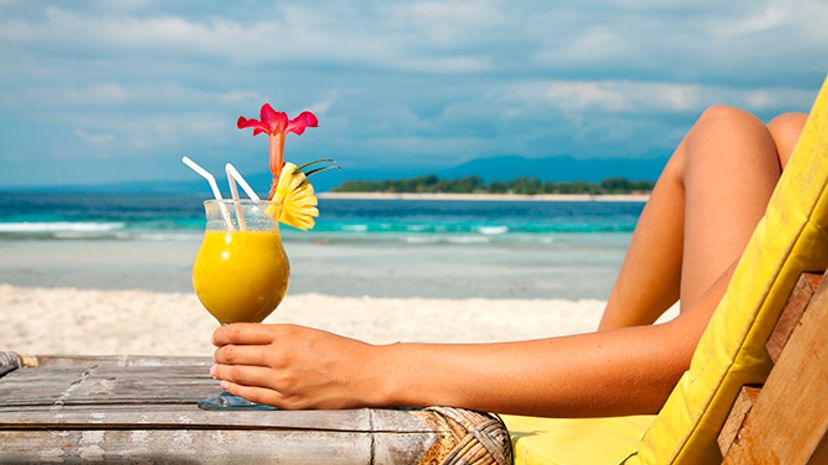 Woman sipping drink in tropical location