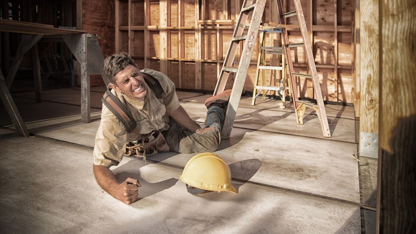 Carpenter building a home at construction site.  Falling off ladder.