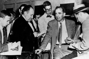 参议员约瑟夫·麦卡锡（Joseph McCarthy）在1953年受到记者的讯问。麦卡锡（McCarthy）因调查所谓的共产主义颠覆而闻名。“border=