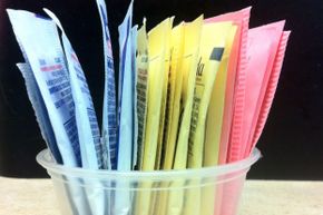 The colored packets of artificial sweeteners that sit on restaurant tables everywhere may be low in calories, but that doesn't mean they're good for you. 
