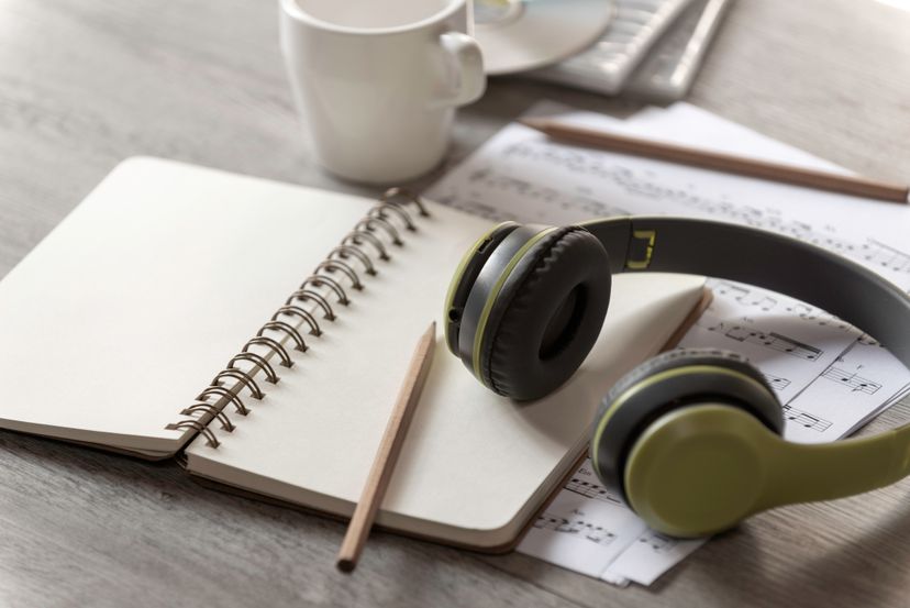 Paper notebook, pencil and earphone with note music paper on the table,Music writer concept, song writer,