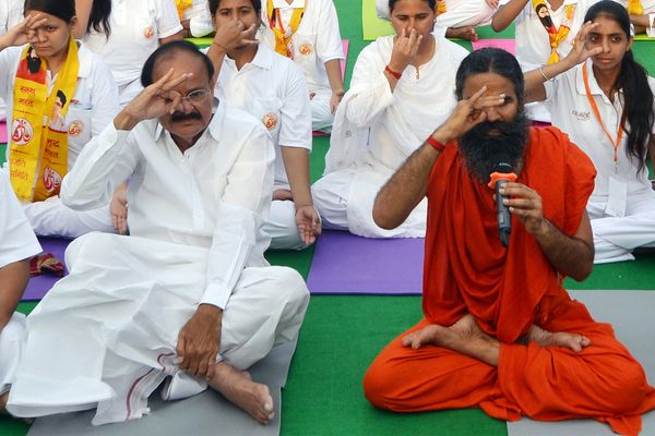 Yoga exponent Ramdev and Union Minister Venkaiah Naidu practice Yoga along with others during a yoga camp ahead of the International Yoga Day on June 21, at Rajpath in New Delhi.
