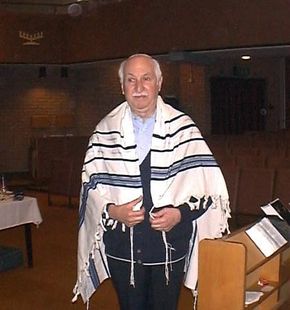 This gentleman wears a white yarmulke and a prayer shawl (a tallit).