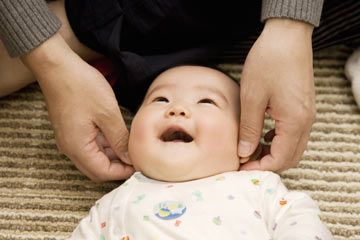 baby getting massaged ears