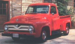 1955年的福特F-100皮卡的特点是上格栅条的v型凹陷。注意V-8标志;六缸版本获得了五星。查看更多经典卡车图片。＂width=