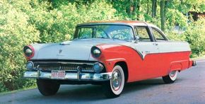 A red 1955 Ford Fairlane Crown Victoria on the street.