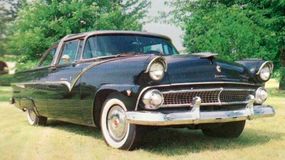 An all-black Ford Fairlane Crown Victoria with whitewall tires.