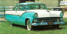 A teal 1955 Ford Fairlane Crown Victoria parked on the grass.