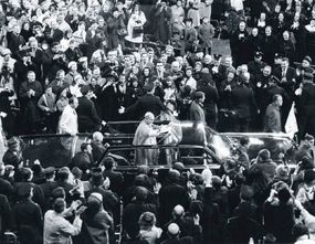 Pope Paul VI waves to an applauding crowd while riding in a specially modified Lehmann-Peterson limousine during his visit to New York City in October 1965.