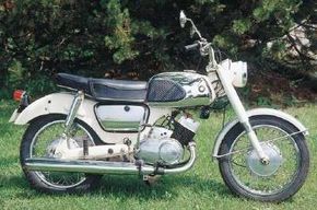 1966年的Suzuki T10旨在将便利性和灵活的发动机性能优先考虑。查看更多摩托车图片。“width=