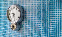 kitchen clock on blue tiled wall