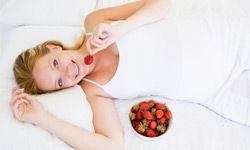 pregnant woman eating strawberries