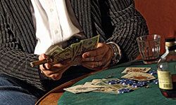 Man counting money at poker table