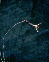 Man bungee jumping off cliff