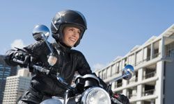 Woman riding motorcycle wearing helmet