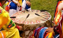 Cultures dancing outdoors in medium group.