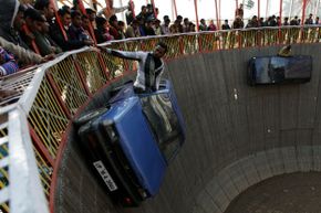Indian performers ride in cars inside a makeshift wooden cylindrical 'Wall of Death' structure, during the annual farmers fair at Shama Chak Jhiri, some 22kms from Jammu.