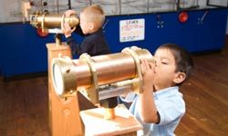 kids check out a telescope at a museum