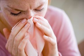 Woman blowing her nose with tissue