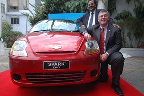 General Motors India President Karl Sylm (front), and Vice President of Corporate Affairs P. Balendran pose with the newly launched liquefied petroleum gas version of the compact Chevrolet Spark in Ahmadabad, India, on June 22, 2009.
