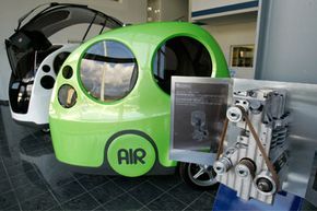 A compressed-air engine is shown on display next to "AirPod" cars at the MDI (Motor Development International) head offices in Carros, near Nice, France, on Jan. 30, 2009.”border=