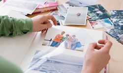 Woman putting family photos in album