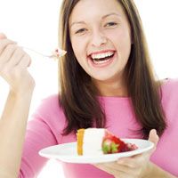 young woman eating a slice of cheesecake