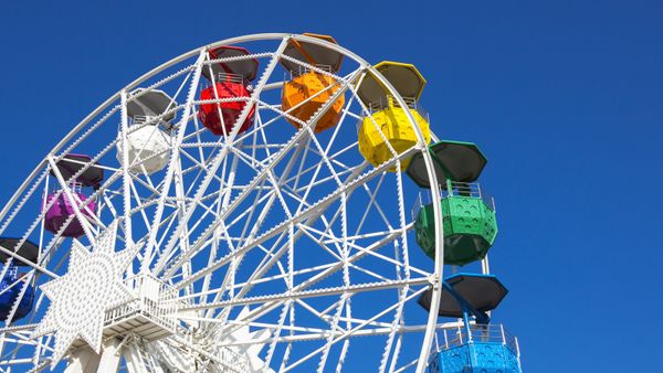 Fun traveling carnival with blue wheel and multi-colored lights.