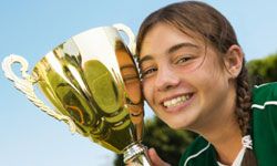 tween girl posing with trophy