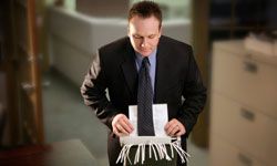 man with his tie caught in a paper shredder