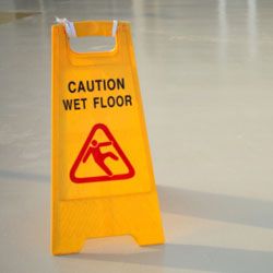 yellow caution sign on wet floor