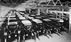 A view inside the Ford Motor Company factory with rows of new Model T motor cars.